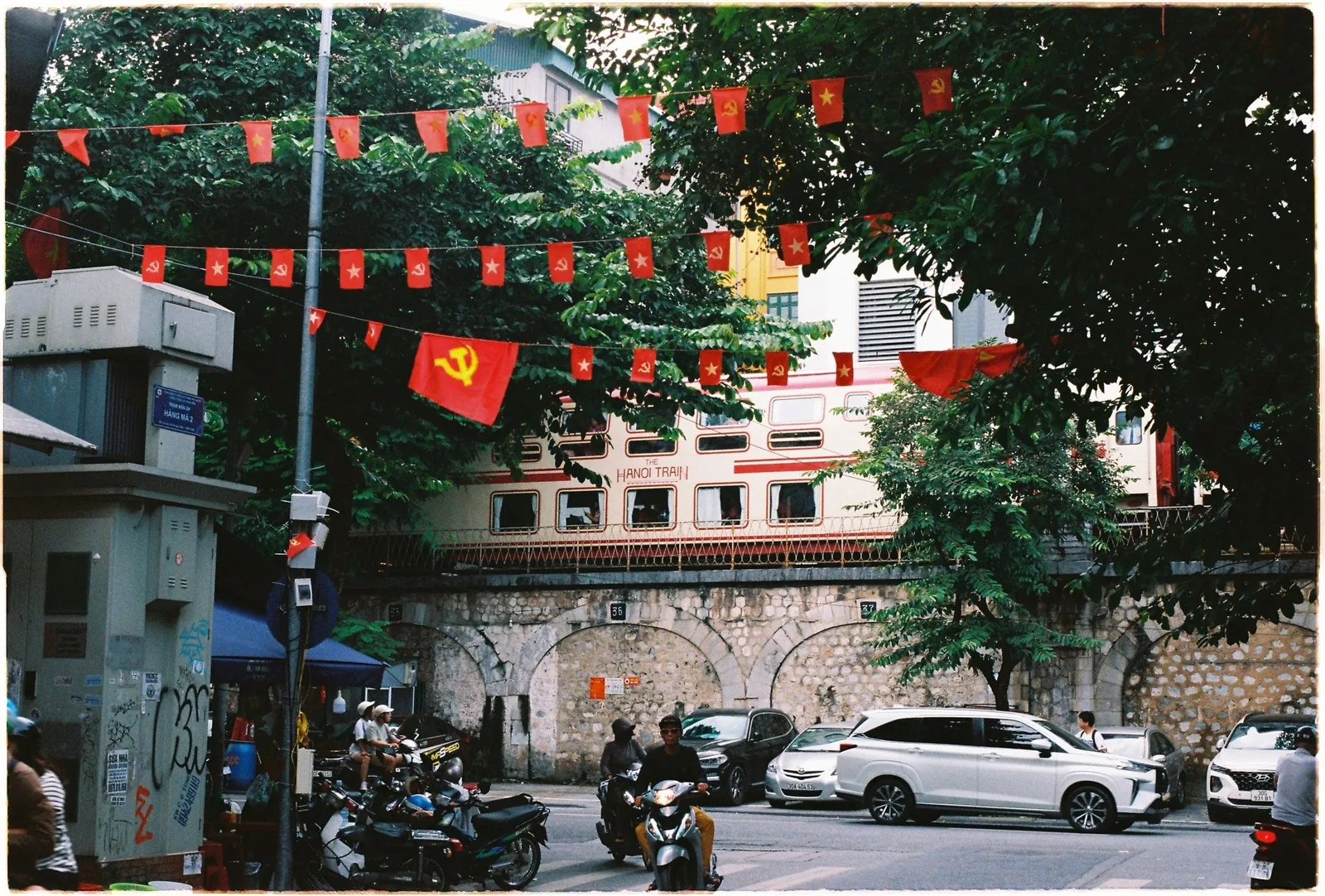 Cờ đỏ treo dưới cầu xe lửa khi xe máy và ô tô qua lại ở Phố Cổ Hà Nội.