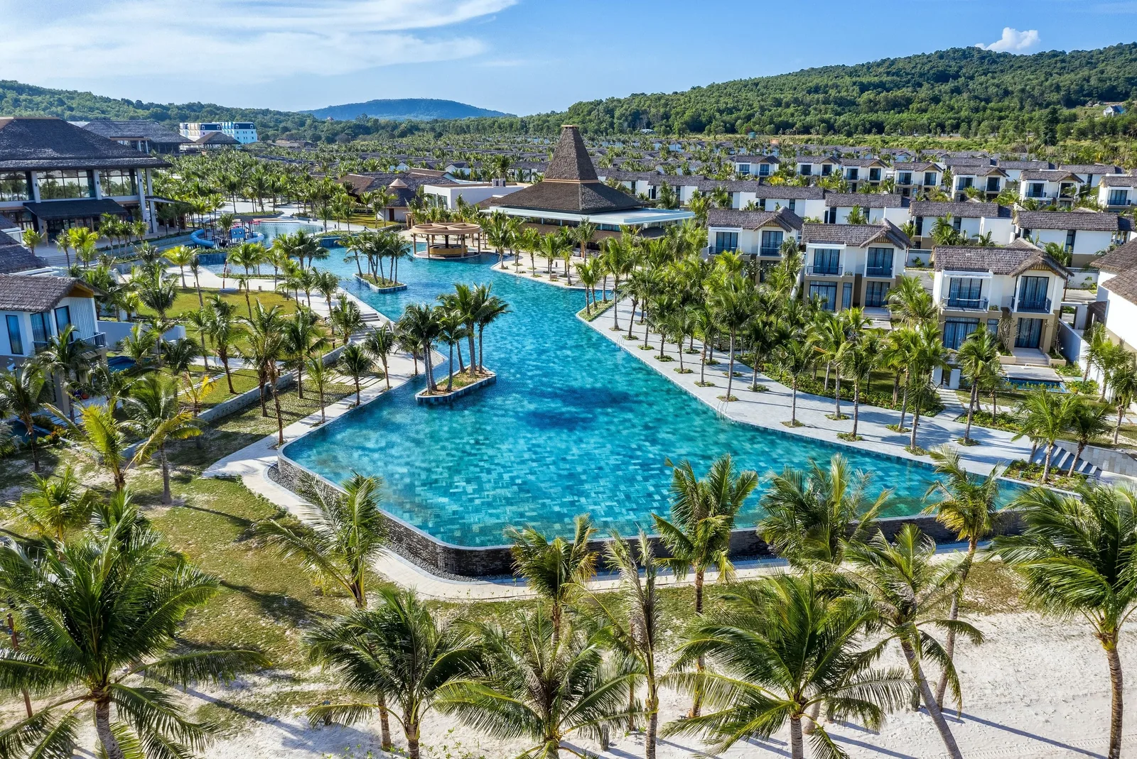 Toàn cảnh khu nghỉ dưỡng trên Hòn Thơm, Phú Quốc với hồ bơi xanh ngọc uốn lượn giữa hàng cọ và biệt thự.